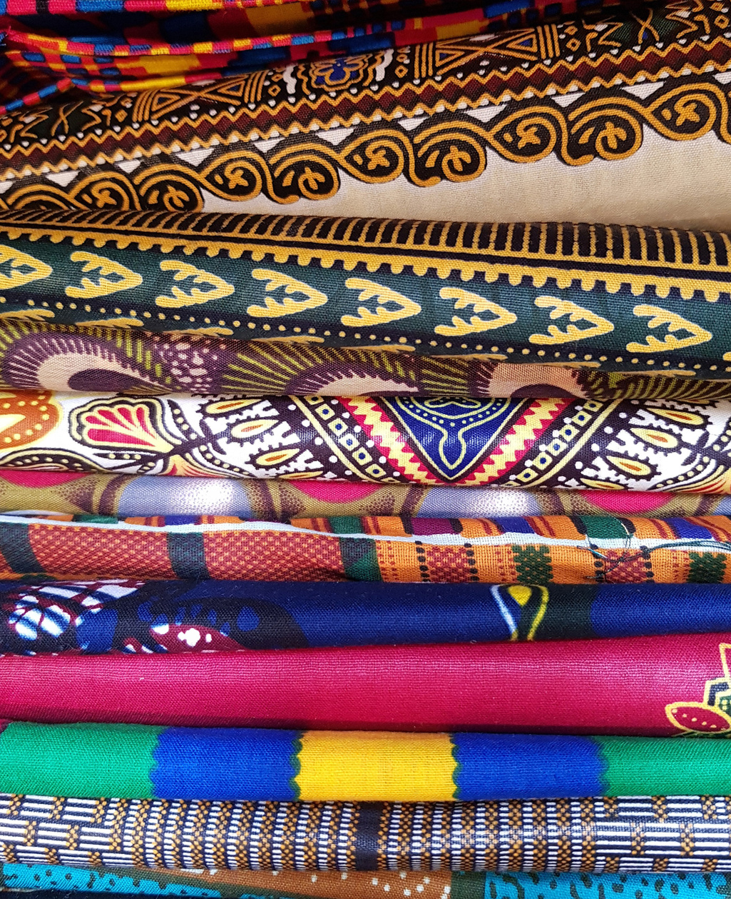 Close-up of stacked colorful African wax-print fabrics